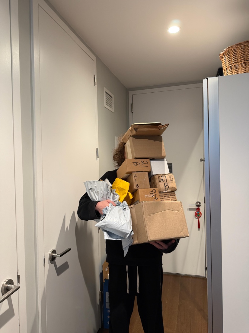 Justin carrying a stack of product sample boxes